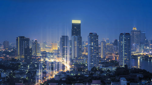 Illuminated buildings in city against sky at night