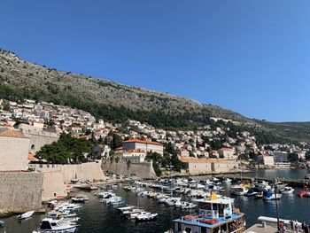 Aerial view of townscape and harbor against clear blue sky