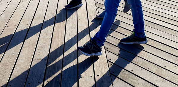 Low section of man standing on boardwalk