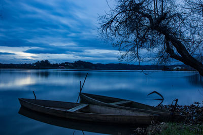 Boat moored in lake against sky