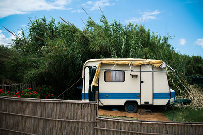 Travel trailer parked against trees on field