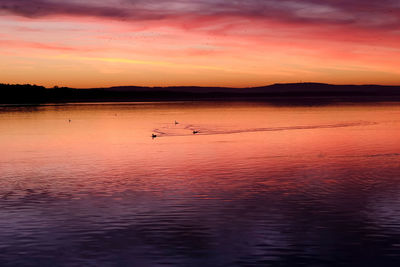Scenic view of lake against orange sky
