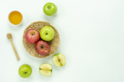 Directly above shot of apples with honey on white background