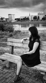 Side view of woman sitting on bench