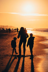 Silhouette people on beach during sunset