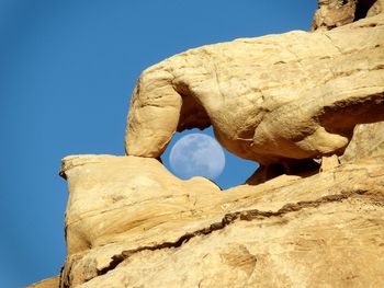 Low angle view of rock formation against clear blue sky