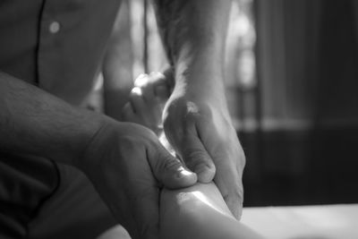 Close-up of father holding baby hand