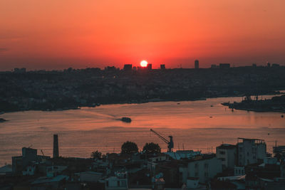 High angle view of silhouette buildings against romantic sky at sunset