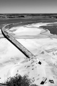 High angle view of twisting road with people on land against sky during summer day