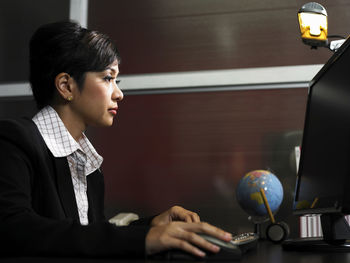 Businesswoman using computer at desk in office