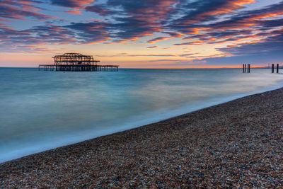 The old destroyed west pier in brighton, uk, after sunset