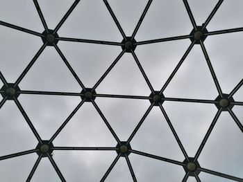 Low angle view of metal fence against sky