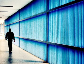 Rear view of man walking on corridor