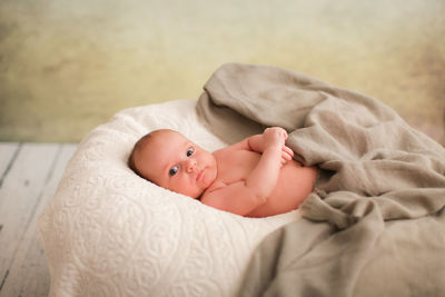 Portrait of cute baby boy lying on bed