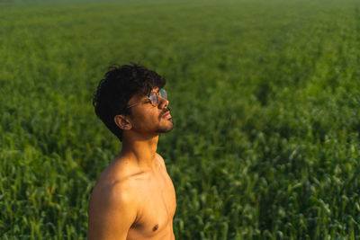 Side view of young man standing on field