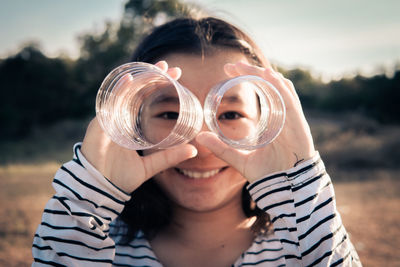 Portrait of smiling girl looking through hole in plastic