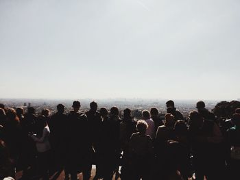 Crowd at sea against sky