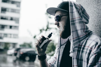 Young man using mobile phone in city