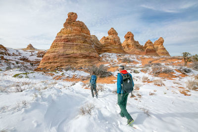 Full length of man standing on snowcapped mountain during winter