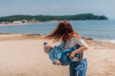 Woman holding umbrella at beach