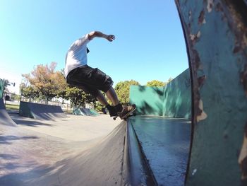 Low angle view of man skateboarding against clear sky