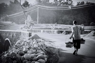 Rear view of woman carrying baskets