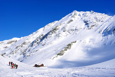 Scenic view of snowcapped mountains against clear blue sky