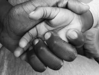 Cropped image of person holding child hand