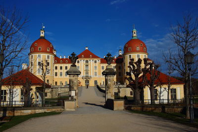 View of buildings in city against blue sky