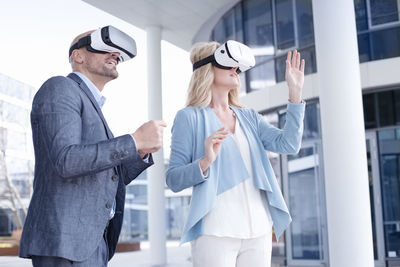 Man and woman wearing virtual reality glasses outdoors