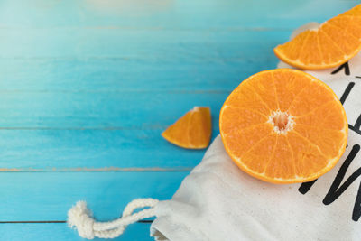 Close-up of orange fruit on table against swimming pool