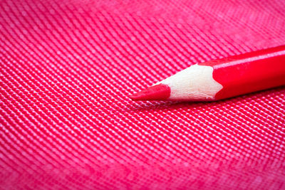 Close-up of red pencil on table