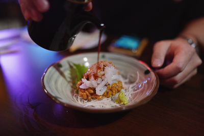 Midsection of woman holding food on table