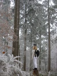 Man holding tree trunk in forest during winter