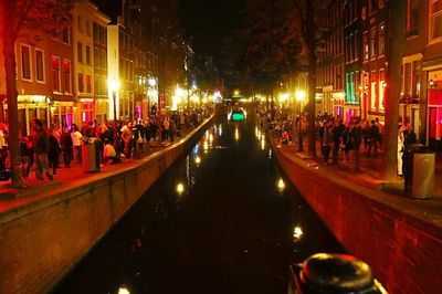 People walking on illuminated street at night