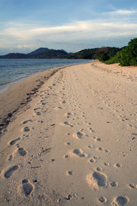 Footprints on beach against sky