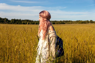 Rear view of woman standing in field