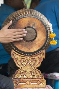 Cropped image of hand playing gong at temple