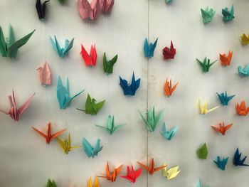 Colorful paper cranes on wall