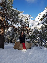 Full length of person standing on snow covered tree