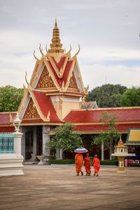 People outside temple against building