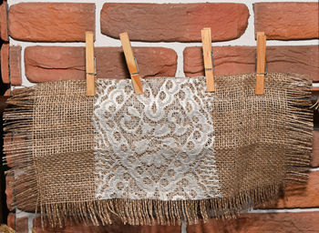 Close-up of patterned fabric sack hanging against brick wall