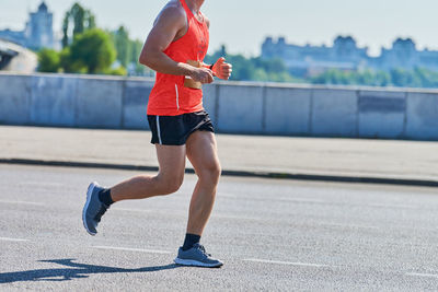 Low section of man running on road