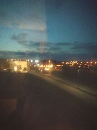 Illuminated city seen through window at night