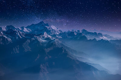 Scenic view of snowcapped mountains against sky at night