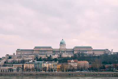 Buildings in city against cloudy sky