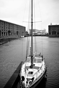 Sailboats moored on harbor in city