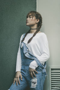 Thoughtful woman standing against wall