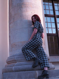 Full length of woman standing against building