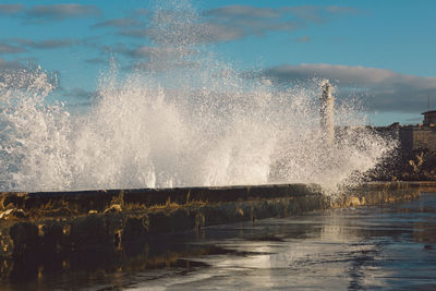 Water splashing in sea against sky